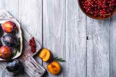 新鲜的甜蜜的李子水果切片板迷迭香叶子切割董事会红色的醋栗浆果