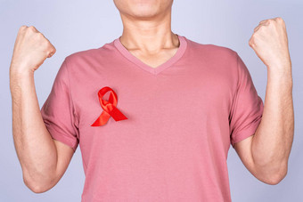 红色的艾滋病意识丝带男人。胸部提高手战斗灰色背景世界艾滋病一天医疗保健医疗概念