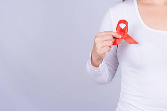 红色的艾滋病意识丝带女人胸部提高手战斗灰色背景世界艾滋病一天医疗保健医疗概念
