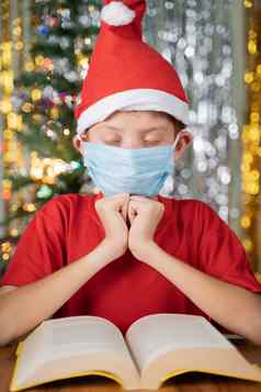 孩子红色的圣诞老人他祈祷前面圣经圣诞节装饰背景礼物表格概念祈祷圣诞节夏娃