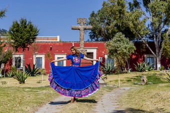 可爱的拉美裔浅黑肤色的女人模型提出了在户外墨西哥牧场