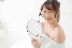 美肖像年轻的亚洲女人微笑脸镜子