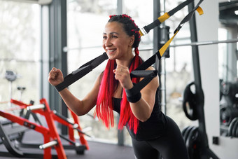 运动员女人培训锻炼悬架系统室内健身房美丽的高加索人运动型女人伸展运动力量锻炼特殊的带