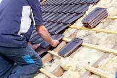 盖屋顶的人铺设瓷砖屋顶