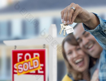 混合比赛夫妇前面出售真正的房地产标志房子