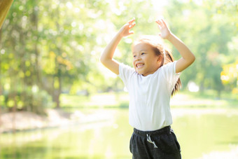 美丽的年轻的亚洲孩子微笑快乐的玩公园