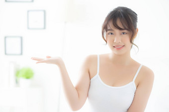 <strong>美</strong>丽的年轻的亚洲女人微笑显示皮肤护理名单的
