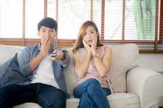 年轻的亚洲夫妇看恐怖电影放松享受