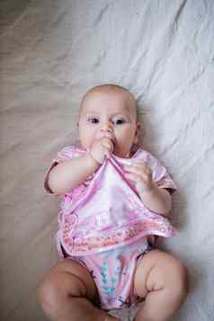 可爱的婴儿女孩亚洲粉红色的服装说谎床上