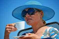 年轻的女人蓝色的他咖啡海滩