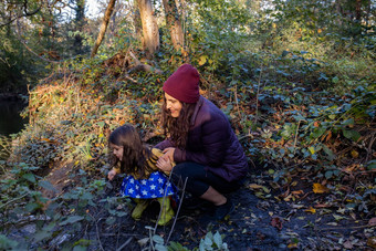 快乐妈妈。女儿探索河森林