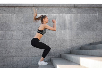 城市运动女人培训女运动员蹲跳跃城市楼梯
