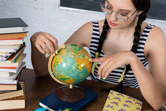 <strong>地理位置</strong>教训少年手表全球安静地计划夏天旅行年轻的女孩眼镜坐在桌子上学校