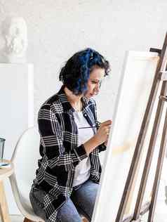 有创意的女人蓝色的染色头发绘画工作室