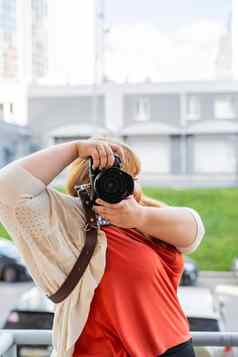 肖像超重女人采取图片相机在户外