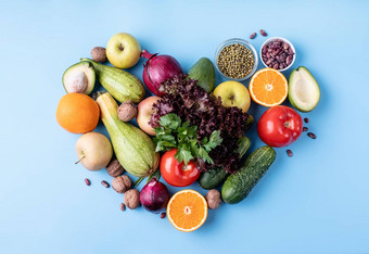 新鲜的水果蔬菜心形状前视图平躺蓝色的背景