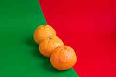 一年假期概念橘子彩色的纸红绿背景
