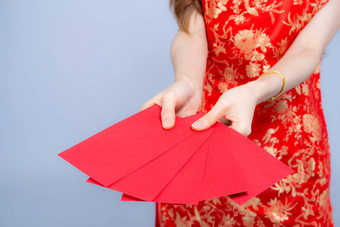 特写镜头亚洲女人旗袍衣服持有红色的信封一点点