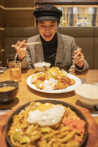 美丽的亚洲女人享受吃日本食物餐厅