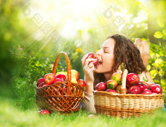 美丽的女孩吃有机苹果果园