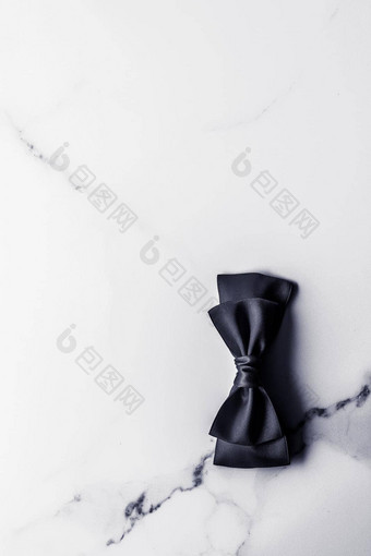 黑色的丝绸丝带弓大理石背景平铺