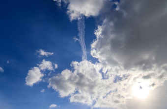 飞机冷凝航迹云的蓝色的天空中间画云