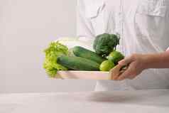 市场健康的素食主义者食物新鲜的蔬菜浆果绿色水果木托盘黄瓜萝卜绿色豌豆白色表格男人。手复制空间