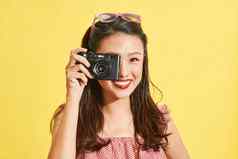 年轻的亚洲女人摄影师持有电影相机