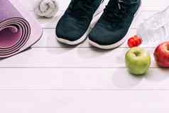 女士们体育配件培训师鞋子哑铃瑜伽席水苹果健身体育运动健康的生活方式概念前视图复制空间