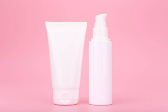 白色化妆品瓶奶油乳液<strong>擦洗脸手</strong>粉红色的背景