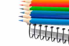 彩色的铅笔笔记本孤立的白色