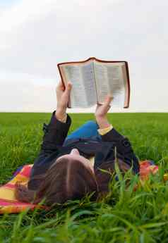 青少年女孩阅读圣经在户外