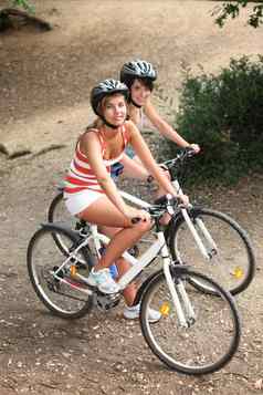 年轻的女孩骑自行车森林