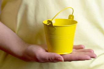 女孩持有小黄色的桶