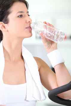 女人喝水瓶健身房