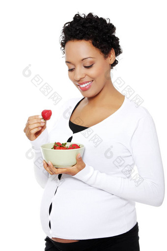 肖像美丽的年轻的女人吃草莓