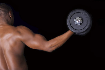 肌肉发达的年轻的男人。提升权重