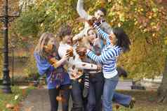 集团十几岁的朋友扔叶子秋天景观