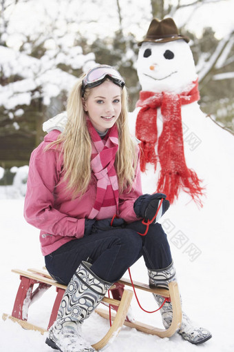 十几岁的女孩雪橇雪人