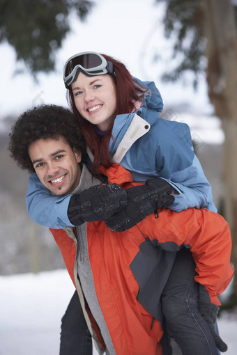 十几岁的男孩给女孩肩扛雪景观