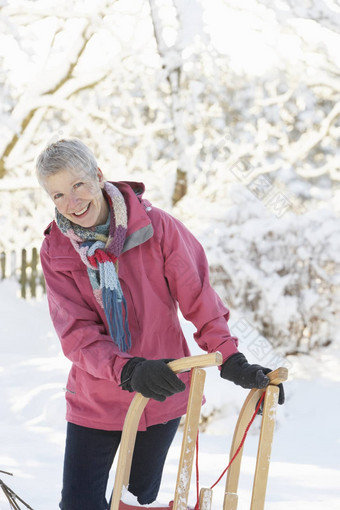 高级女人持有<strong>雪</strong>橇<strong>雪</strong>景观