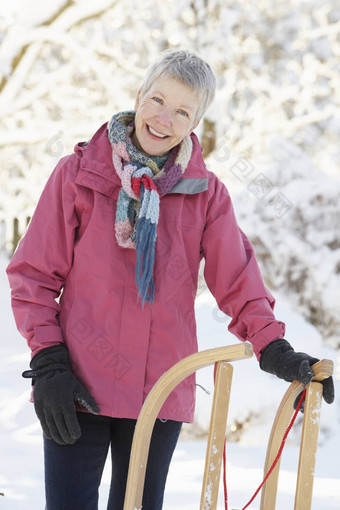 高级女人持有<strong>雪</strong>橇<strong>雪</strong>景观