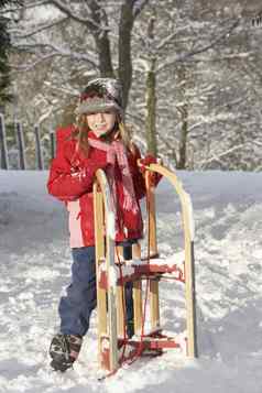 年轻的女孩持有雪橇雪景观