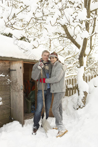 年轻的夫妇清算雪路径木商店