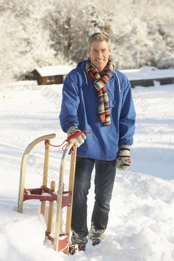 中间岁的男人。站<strong>雪</strong>景观持有<strong>雪</strong>橇