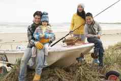 家庭集团坐着船钓鱼杆冬天海滩