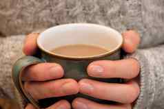 手保持温暖的持有热杯茶咖啡