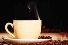 热气腾腾的咖啡杯咖啡豆子黄麻织物