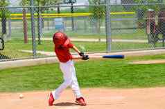 年轻的棒球球员摆动蝙蝠