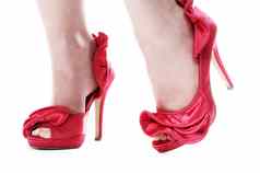 关闭女士脚红色的高跟鞋孤立的白色